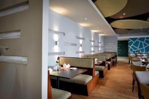 卢萨卡开罗路普罗蒂亚酒店 的用餐室配有桌椅