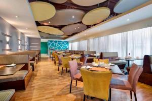 卢萨卡开罗路普罗蒂亚酒店 的餐厅设有桌椅和带镜子的天花板