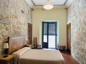 赫罗纳昆达罗之家酒店的一间卧室设有一张床和石墙