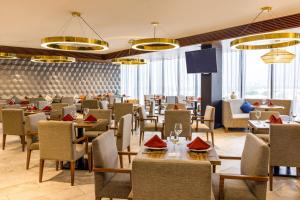 墨西哥城墨西哥城瓦列霍万怡酒店的餐厅设有桌椅和窗户。