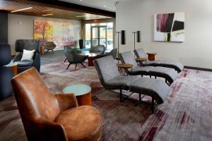 休斯顿休斯顿洲际机场万怡酒店 的带沙发、椅子和桌子的等候室