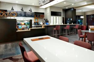 休斯顿休斯顿洲际机场万怡酒店 的餐厅设有酒吧,配有桌椅