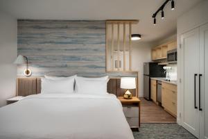 拉斯维加斯TownePlace Suites by Marriott Las Vegas North I-15的一间带白色大床的卧室和一间厨房