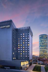 布加勒斯特Courtyard by Marriott Bucharest Floreasca的黄昏时法院庭院旅馆 ⁇ 染