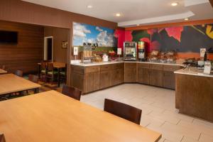 拉斐特拉斐特I-10万豪费尔菲尔德酒店的餐厅设有木桌和食品柜台。
