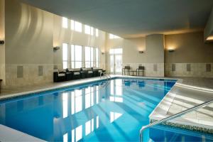 大急流城万豪格兰德急瑞比机场原住酒店的大楼内一个蓝色的大型游泳池