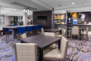 夏洛特Fairfield Inn & Suites Charlotte Pineville的一间带桌椅的餐厅和一间酒吧