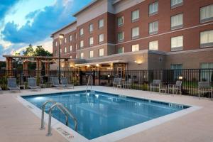 夏洛特Fairfield Inn & Suites Charlotte Pineville的大楼前的酒店游泳池