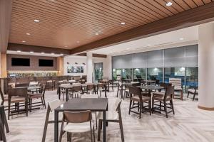 休斯顿Fairfield Inn & Suites Houston Memorial City Area的一间带桌椅的餐厅和一间酒吧