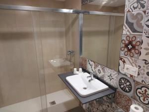 圣多明各德拉Hotel - Hostel Atuvera的一间带水槽和玻璃淋浴的浴室