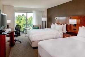 切萨皮克切萨皮克诺福克万豪三角洲酒店 的酒店客房设有两张床、一张桌子和一台电视。