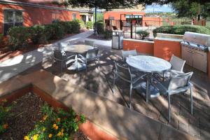 土桑土桑万豪广场套房酒店的庭院配有桌椅、桌子和椅子。