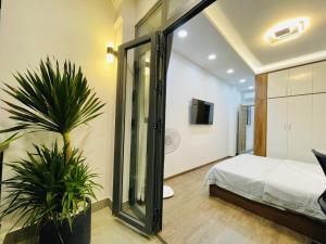胡志明市Thai Van Home的一间卧室配有一张床和盆栽植物