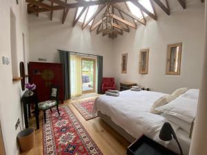 邓弗里斯The Stables - Luxury Cottage的一间卧室设有一张大床和一个窗户。