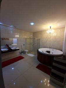 维列纳Hotel e Locadora Vizon的带浴缸和卫生间的大型浴室