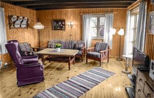 HjelmelandAwesome Home In Skiftun With 2 Bedrooms And Wifi的客厅配有椅子、桌子和电视