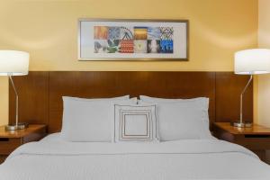 坦帕坦帕布兰登万豪费尔菲尔德套房酒店的卧室配有带两盏灯的白色床