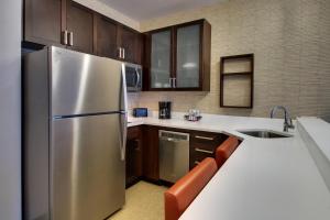 Collegeville费城福吉谷/科利奇维尔万豪原住酒店的厨房配有不锈钢冰箱和木制橱柜