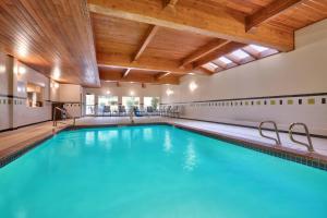 贝尔维尤西雅图贝尔维尤/雷德蒙费尔菲尔德套房酒店的一座拥有木质天花板的建筑中,设有一座蓝色海水室内游泳池