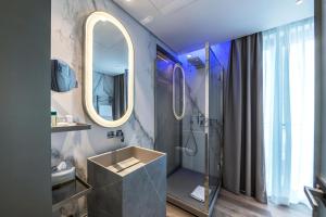 罗马The Regency, Rome, a Tribute Portfolio Hotel的带淋浴、盥洗盆和镜子的浴室