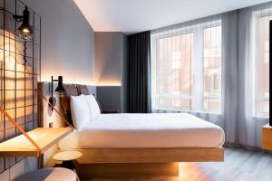 海牙Moxy The Hague的一间卧室设有一张床和一个大窗户