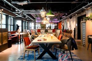 海牙Moxy The Hague的用餐室配有桌椅和桌椅
