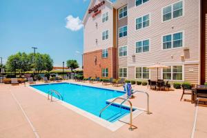 罗阿诺Residence Inn by Marriott Roanoke Airport的酒店前方设有桌椅的游泳池