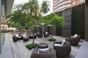 危地马拉危地马拉城万怡酒店的庭院配有沙发、桌子和树木