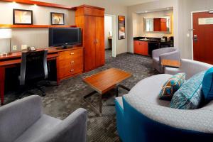 格林斯堡匹兹堡格林万怡酒店的客厅配有沙发和书桌及电视