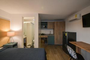 瓜达拉哈拉Expo Satelite Hotel & Suites的一间卧室配有一张床,厨房配有桌子