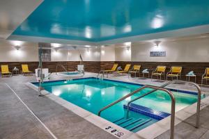 亚历山德里亚Fairfield Inn & Suites by Marriott Alexandria,Virginia的酒店客房的大型游泳池配有黄色椅子