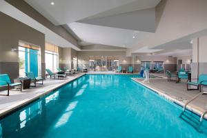 特克萨卡纳-德克萨斯特克萨卡纳万豪原住客栈的一个带蓝色椅子的酒店客房的游泳池