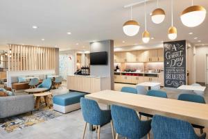 坦帕TownePlace Suites by Marriott Tampa Casino Area的一间设有桌椅和厨房的自助餐厅