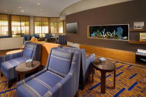 圣安东尼奥圣安东尼奥海洋世界/拉克兰万怡酒店的一间设有蓝色椅子和平面电视的等候室