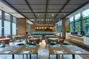 南昌南昌华侨城福朋喜来登酒店的餐厅设有桌椅和窗户。