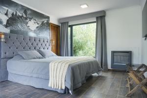 埃尔卡拉法特Patagonia Hope Suites的一间卧室设有一张大床和一个大窗户