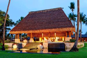 丹娜努斐济丹娜拉岛威斯汀spa度假酒店的拥有茅草屋顶和棕榈树的度假酒店