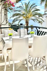 锡蒂奥卡拉翁达MI CAPRICHO 4C BEACHFRONT -Apartment with sea view - Costa del Sol的棕榈树阳台的白色桌椅