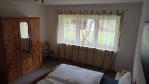 巴特布吕克瑙Leimbach的一间卧室配有床和带窗帘的窗户