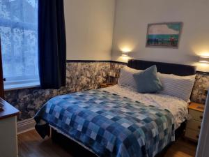 布莱克浦Sirocco Blues Guest House的一间卧室配有一张带蓝色铺面毯子的床