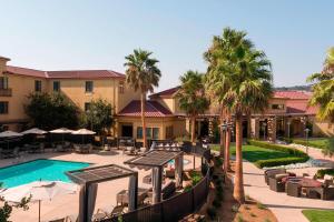 纳帕纳帕谷春季山丘套房酒店的一个带桌椅的度假村游泳池,并种植了棕榈树