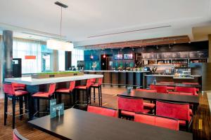 霍姆斯泰德迈阿密家园万怡酒店的一间设有红色桌椅的餐厅和一间酒吧