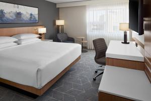 卡尔加里Delta Hotels Calgary Airport In-Terminal的配有一张床和一张书桌的酒店客房