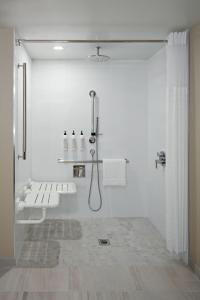 卡尔加里Delta Hotels Calgary Airport In-Terminal的带淋浴和盥洗盆的白色浴室