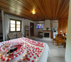 蒙特韦尔迪Chalés Leopoldo em Monte Verde的一间卧室配有一张红色鲜花的大床