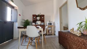 法鲁Monte da ti Luzia的客厅配有桌子和白色椅子
