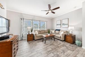 格尔夫海岸GulfShores BeachCondo - Pool - FreeParking - SummerTime! - Little Lagoon的带沙发和吊扇的客厅