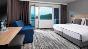 泽勒兹纳·鲁达OREA Resort Horizont Šumava的酒店客房设有一张床和一个大窗户