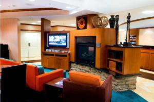 沃恩Residence Inn by Marriott Toronto Vaughan的客厅配有橙色椅子和平面电视
