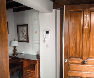 格拉纳达Apartamentos en pleno centro, Aljibe Rodrigo del Campo 2A的客房设有书桌和木门。